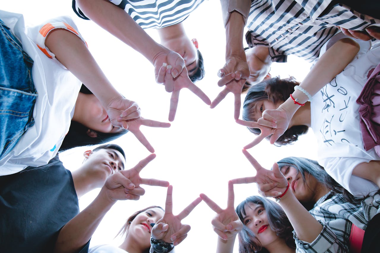 portfolio-03 A circle of friends forming a star shape with fingers, symbolizing unity and teamwork.