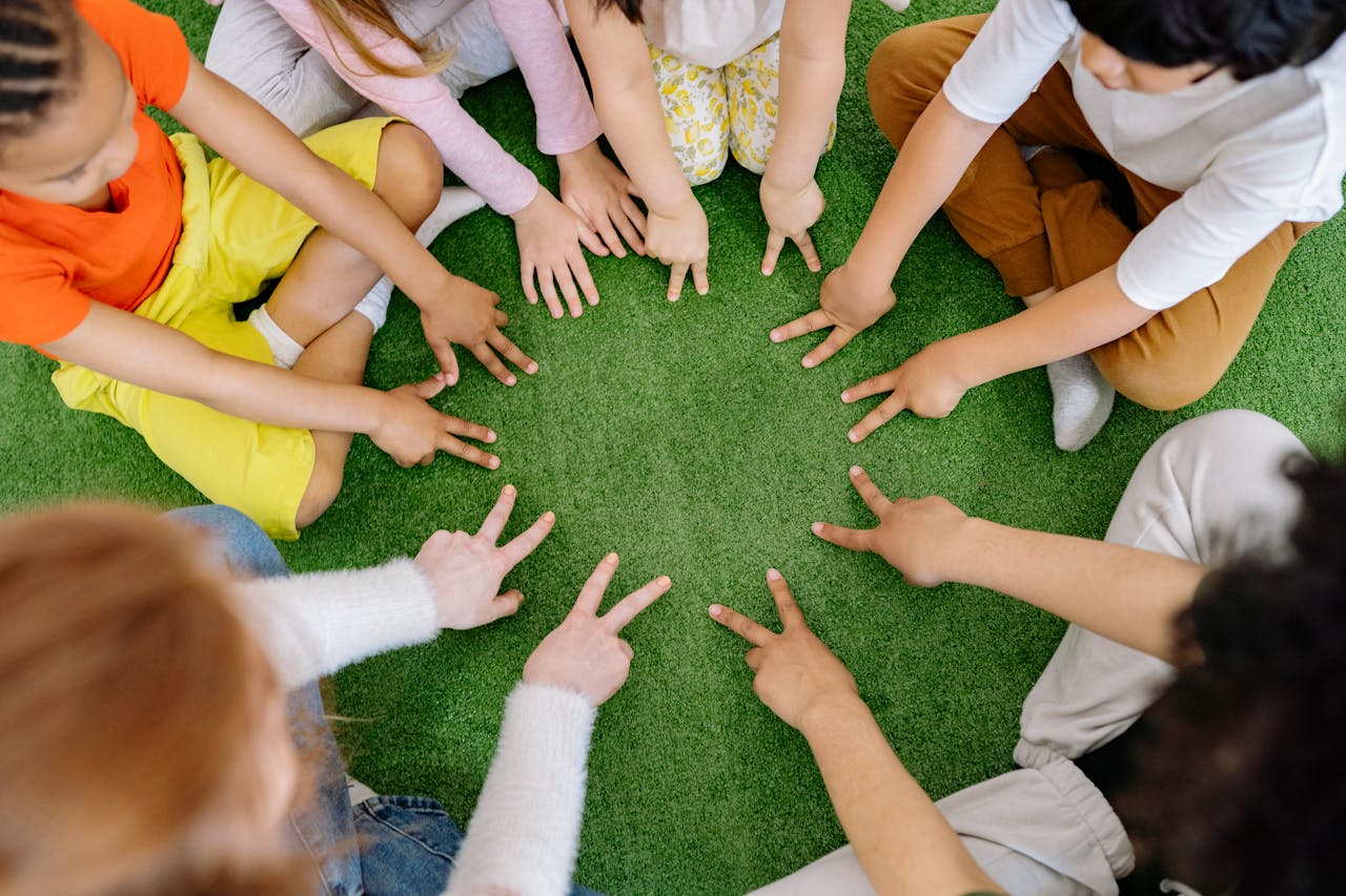 portfolio-04 Children sitting in a circle playing fun team games on artificial grass.