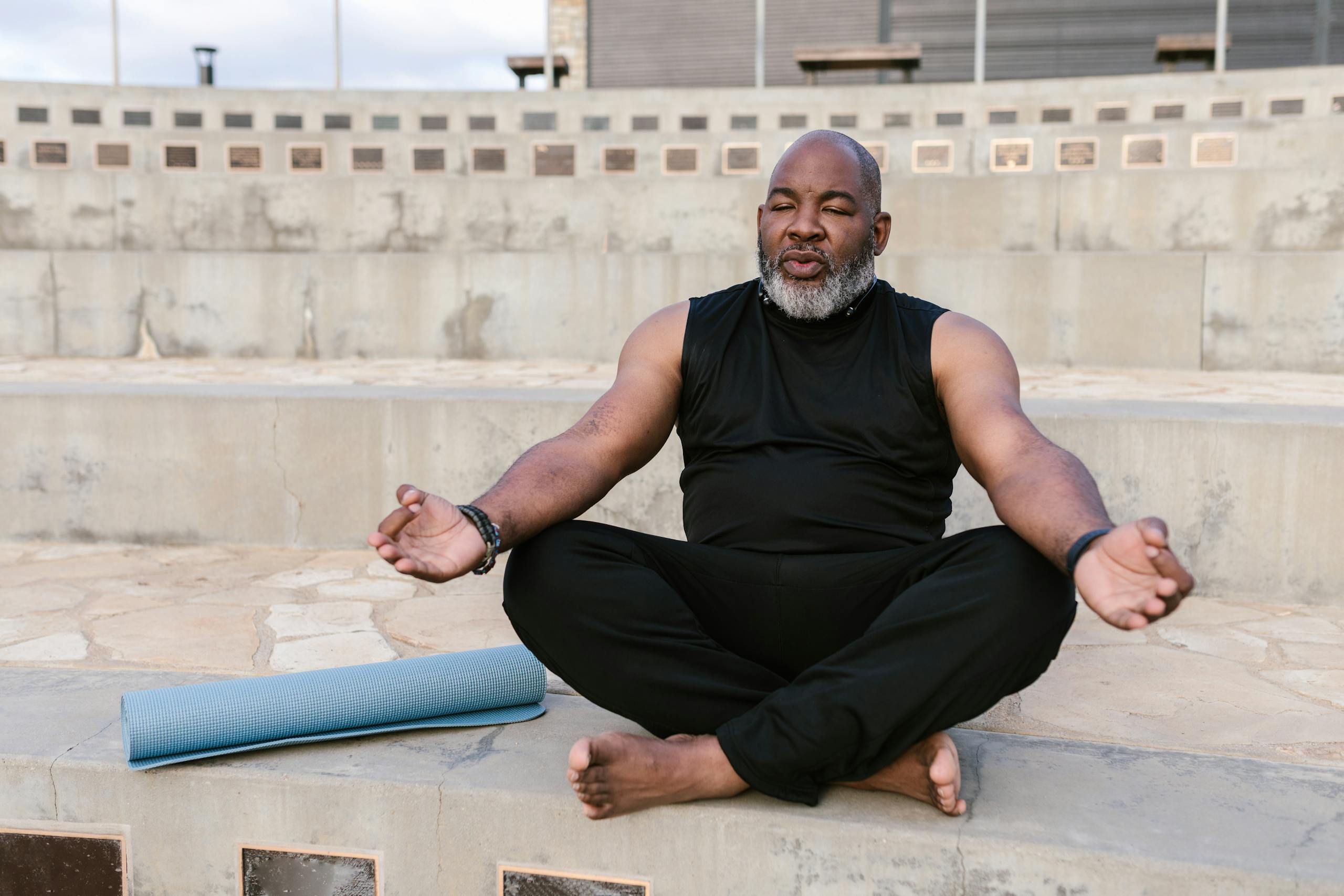 Senior man meditating outdoors promoting tranquility and wellness through yoga practice.
